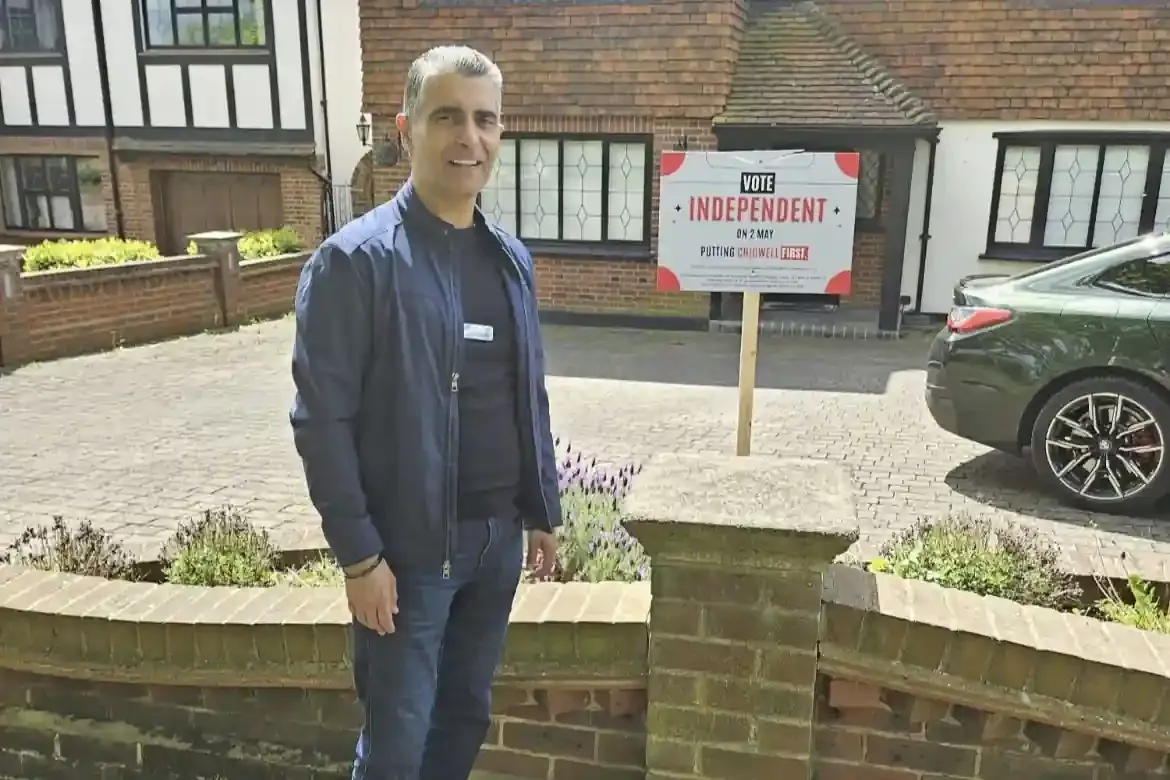 Sunny Sandhu standing next to a vote EFIG sign